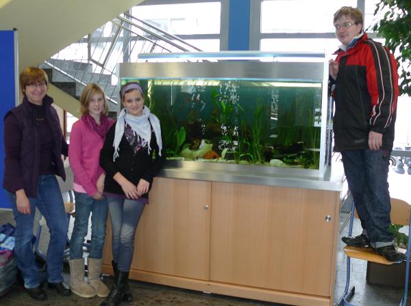 Anne Weller, Leiterin der Aquarien-AG, mit AG-Mitgliedern vor dem neuen Aquarium